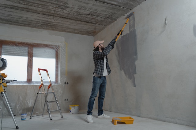 person painting walls gray