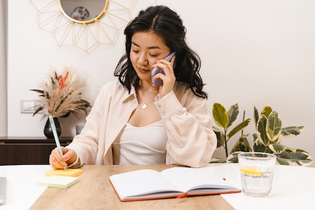 property-manager-on-phone-with-tenant-sitting-at-desk