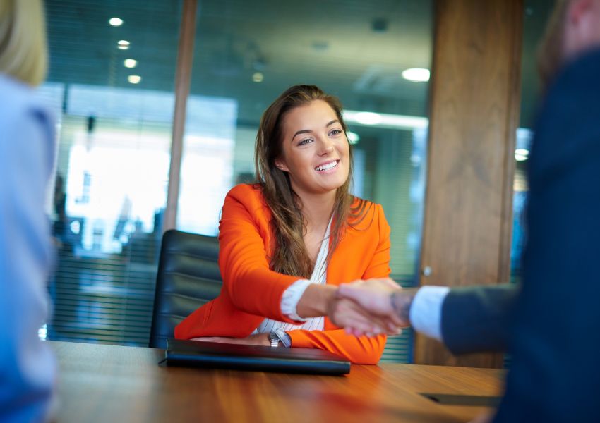 person-shaking-hands-over-table